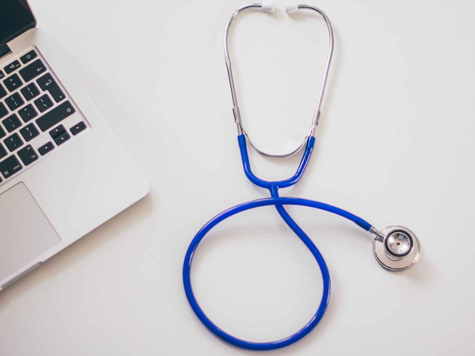 Symbolfoto Gesundheit und Digitalisierung, ein Stethoskop und ein Laptop