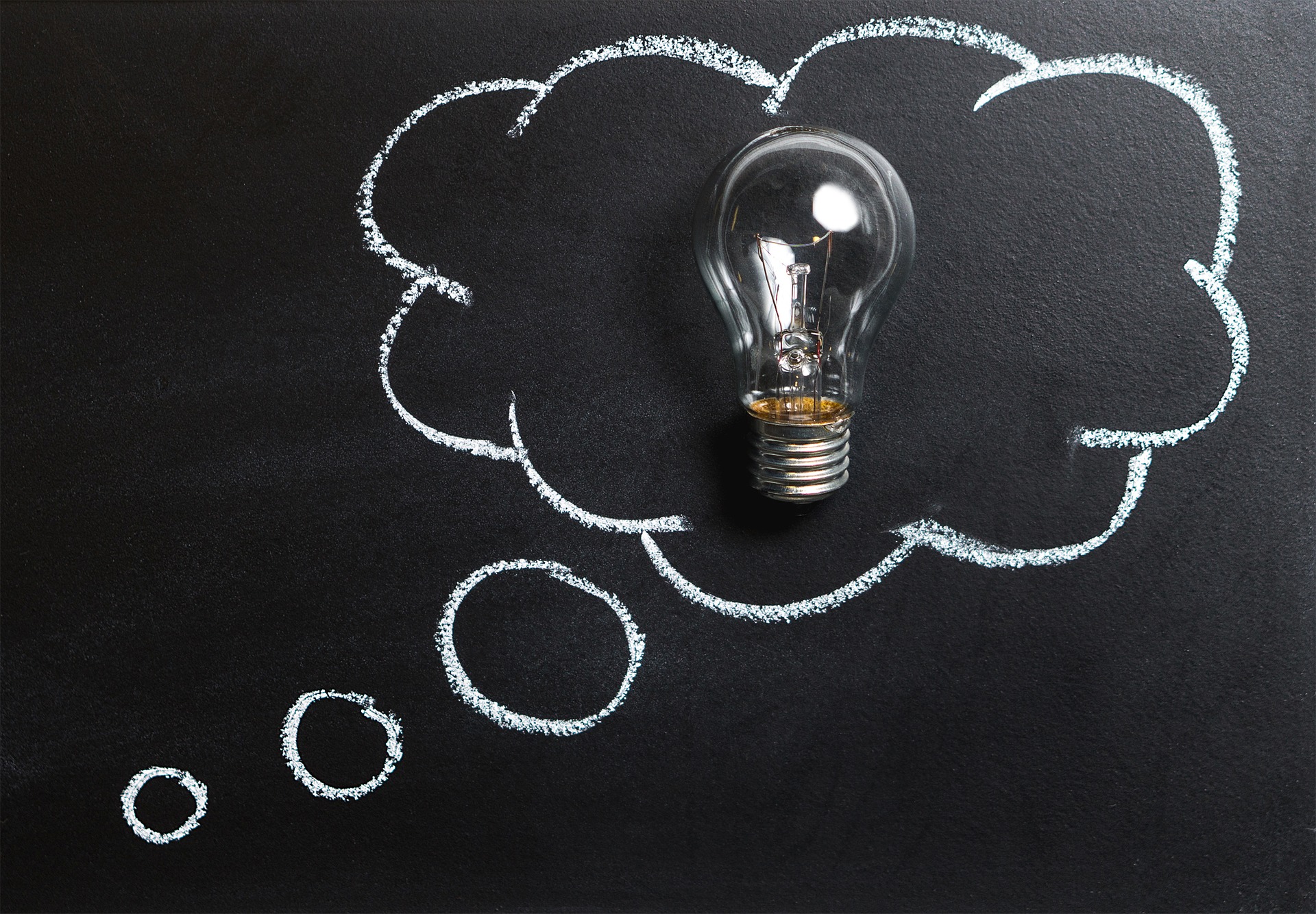 Eine Glühlampe in einer Denkblase als Sinnbild für Gedanken, Idee, Innovation