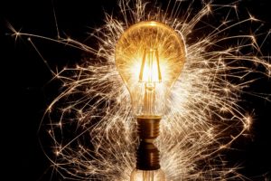Symbolbild Innovation und Ideen: Funken sprühen aus eine Glühlampe.