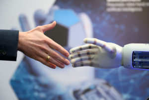 Eine menschliche und eine Roboterhand begegnen sich bei der Hannover Messe