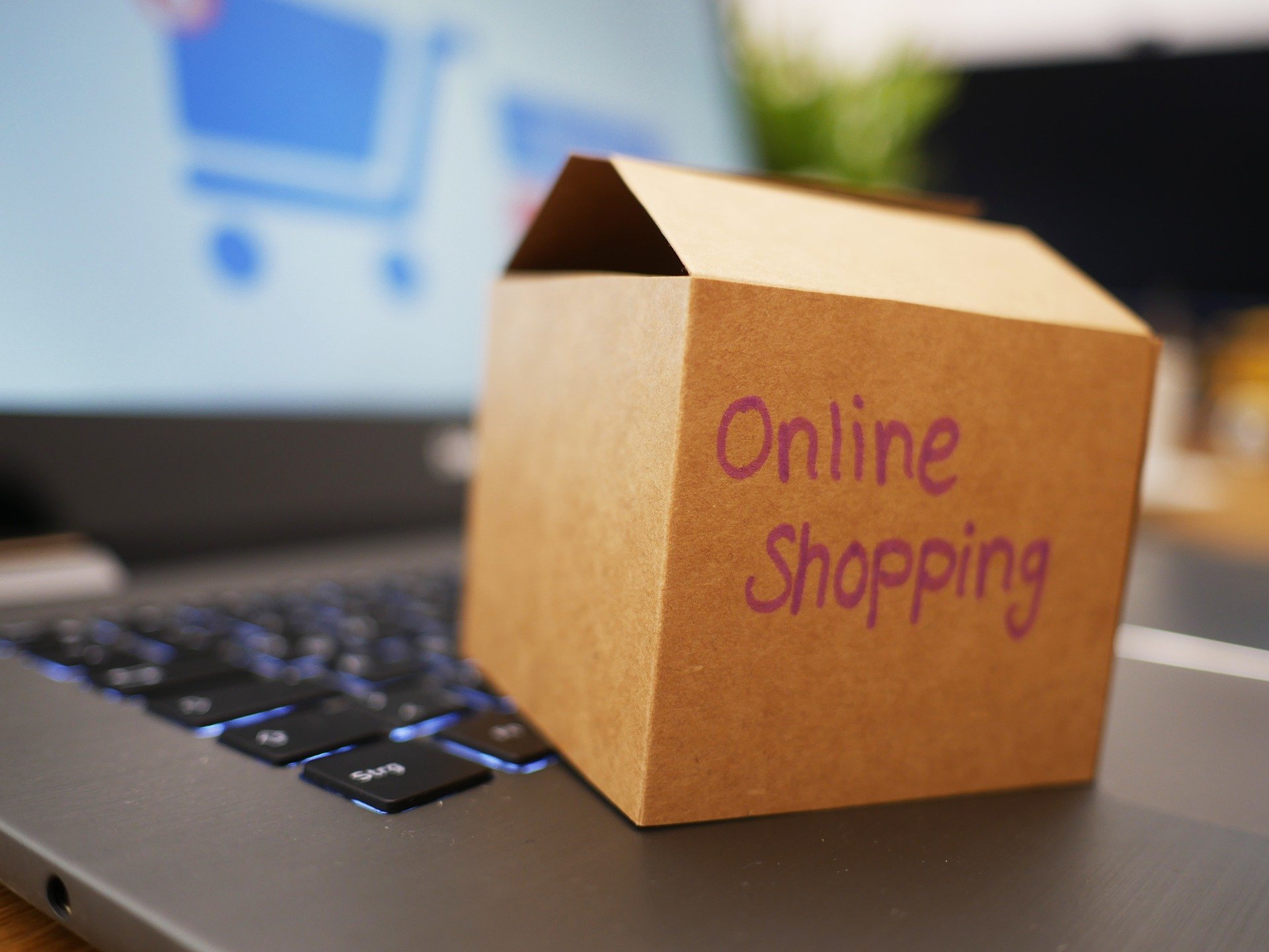 Kleines Paket mit der Aufschrift Online Shopping auf einer Laptoptastatur.