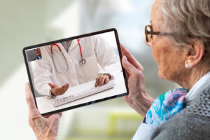 Seniorin spricht über das Tablet mit ihrem Arzt