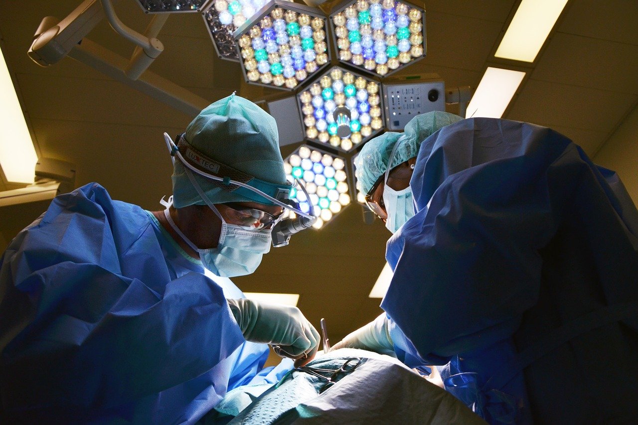 Laufende Operation in einem OP-Saal mit Patient und medizinischem Personal.