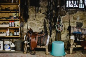 Blick in eine Werkstatt mit Sätteln und Zaumzeug für Pferde.