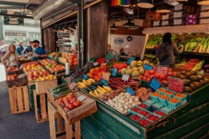 Bunter Marktstand mit Obst und Gemüse.