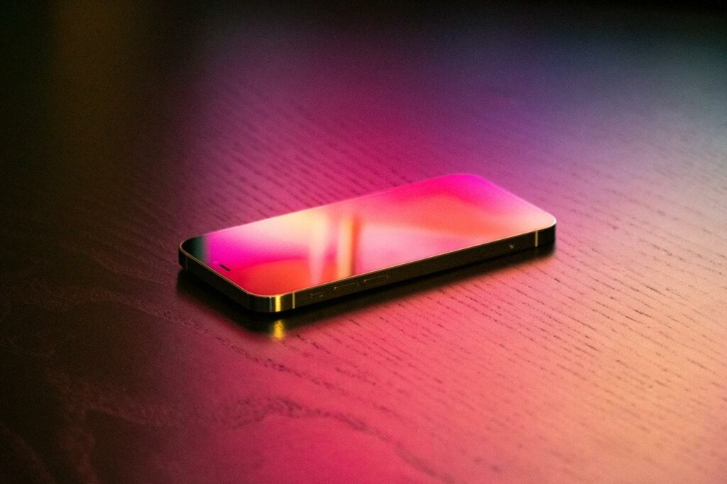 IPhone in rötlichem Licht auf einem Tisch.