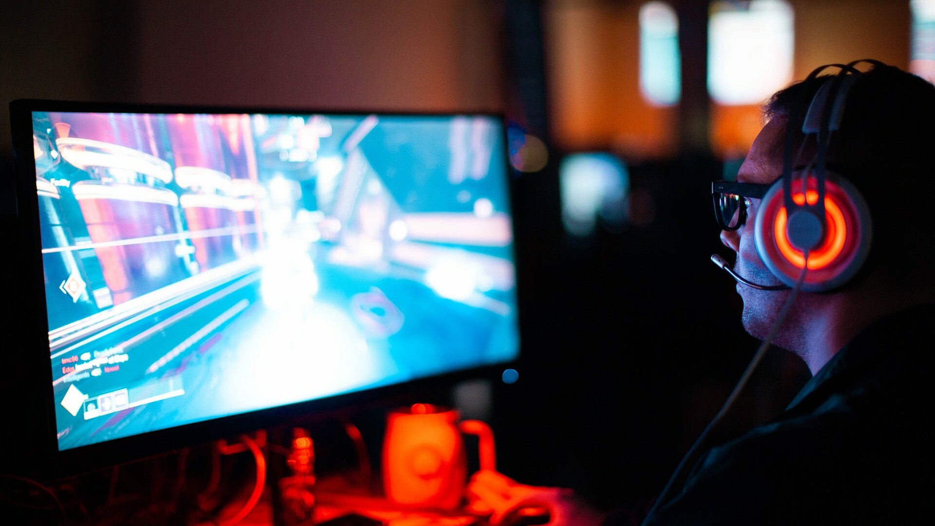 Ein Mann mit Headset sitzt am Computer und spielt ein Videospiel.