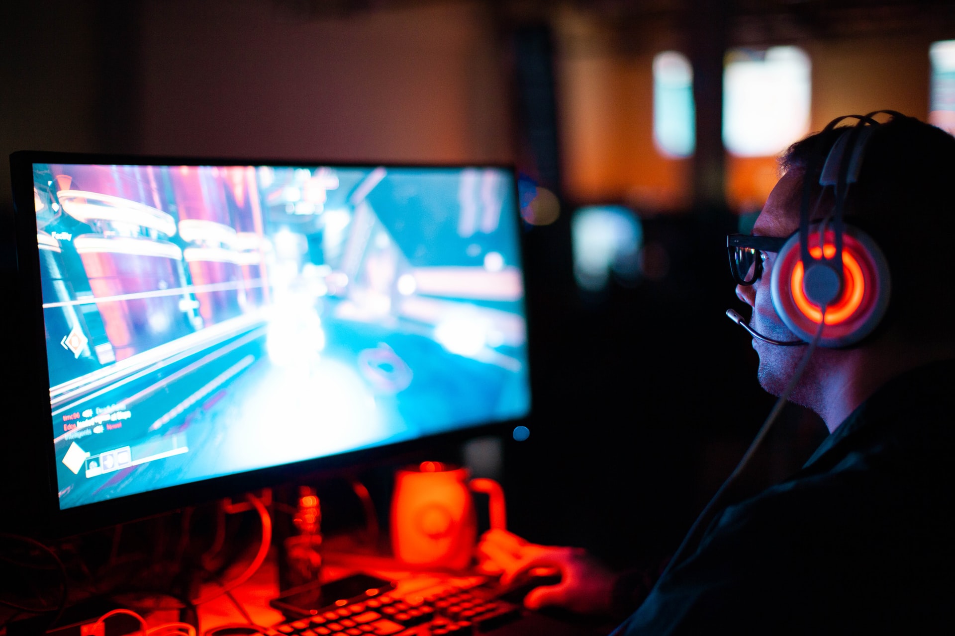 Ein Mann mit Headset sitzt am Computer und spielt ein Videospiel.