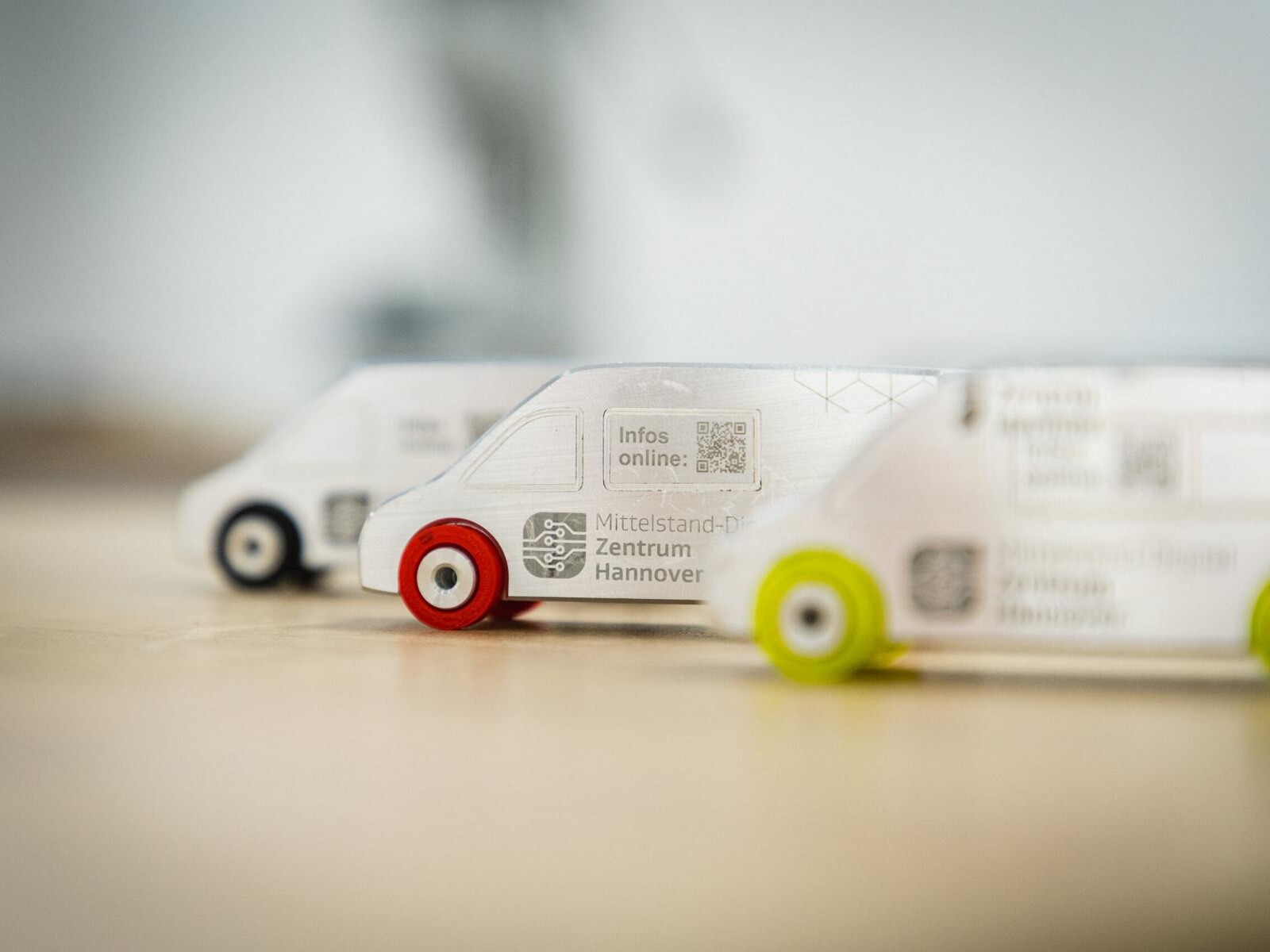Drei am 3D-Drucker entstandene Fahrzeugmodelle mit dem Logo des MDZ Hannover.