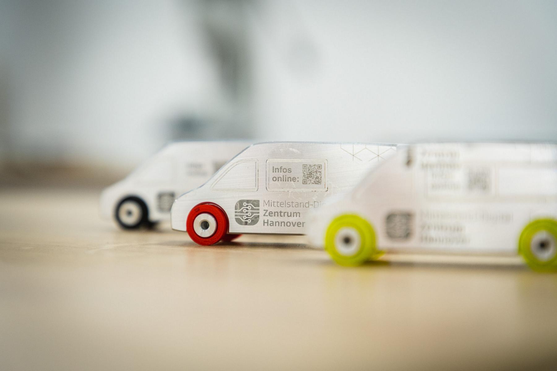 Drei am 3D-Drucker entstandene Fahrzeugmodelle mit dem Logo des MDZ Hannover.