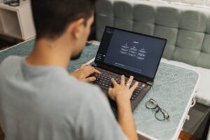 Ein Mann sitzt am Laptop und bedient ChatGPT.